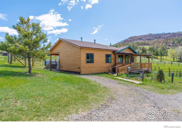 519 Palisade Mountain Dr, Drake, CO 80515 - back of house featuring log veneer siding, a lawn, gravel driveway, and a porch