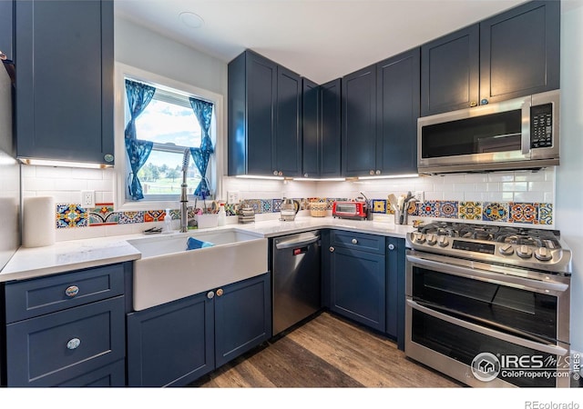519 Palisade Mountain Dr, Drake, CO 80515 - kitchen with appliances with stainless steel finishes, a sink, dark wood-style flooring, and blue cabinets