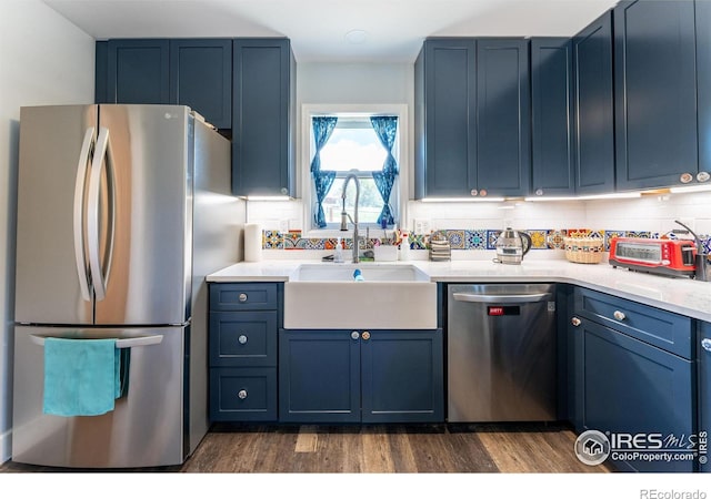 519 Palisade Mountain Dr, Drake, CO 80515 - kitchen with stainless steel appliances, a sink, blue cabinetry, and dark wood-style flooring