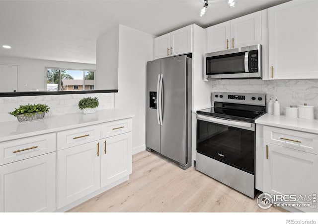 5329 Flower Cir, Arvada, CO 80002 - kitchen featuring stainless steel appliances, light wood finished floors, white cabinets, and decorative backsplash