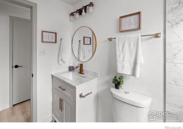 5329 Flower Cir, Arvada, CO 80002 - bathroom featuring vanity, toilet, and wood finished floors