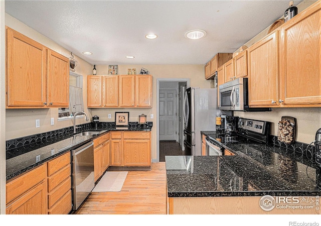 3525 Auntie Stone St Unit 7, Fort Collins, CO 80526 - kitchen featuring appliances with stainless steel finishes, a sink, light wood-style floors, recessed lighting, and dark stone countertops