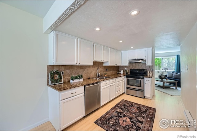 2977 Eagle Way, Boulder, CO 80301 - kitchen featuring appliances with stainless steel finishes, under cabinet range hood, a sink, decorative backsplash, and white cabinetry