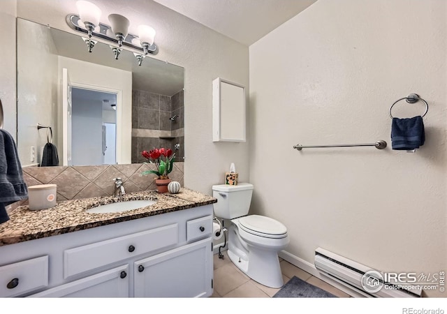 2977 Eagle Way, Boulder, CO 80301 - bathroom featuring tile patterned floors, vanity, toilet, a baseboard radiator, and tiled shower