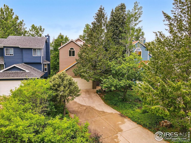 4489 Wellington Rd, Boulder, CO 80301 - view of front of home with a chimney, roof with shingles, and concrete driveway
