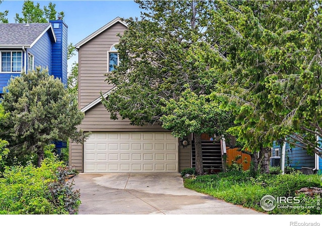 4489 Wellington Rd, Boulder, CO 80301 - view of property hidden behind natural elements featuring concrete driveway, stairway, and a garage