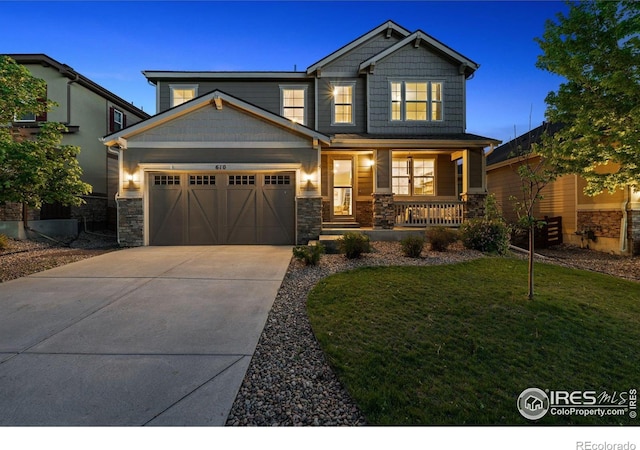 610 Sun Up Pl, Erie, CO 80516 - craftsman house featuring covered porch, stone siding, driveway, an attached garage, and a front lawn