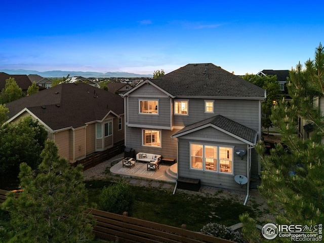 610 Sun Up Pl, Erie, CO 80516 - back of house at dusk with an outdoor hangout area and a wooden deck