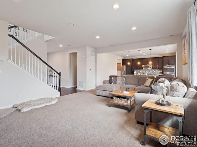610 Sun Up Pl, Erie, CO 80516 - carpeted living area with recessed lighting, stairs, and baseboards