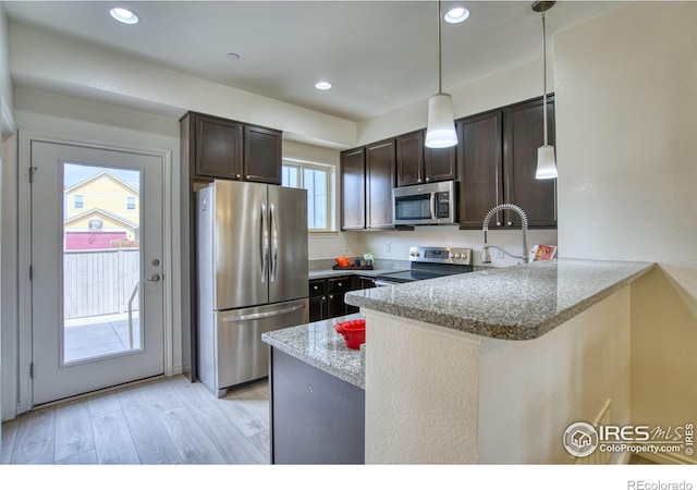 1240 Wren Ct Unit B, Longmont, CO 80501 - kitchen featuring stainless steel appliances, a peninsula, dark brown cabinets, light wood-style flooring, and a sink