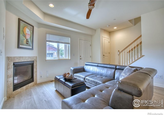 1240 Wren Ct Unit B, Longmont, CO 80501 - living room with light wood-style floors, stairs, baseboards, a tiled fireplace, and recessed lighting