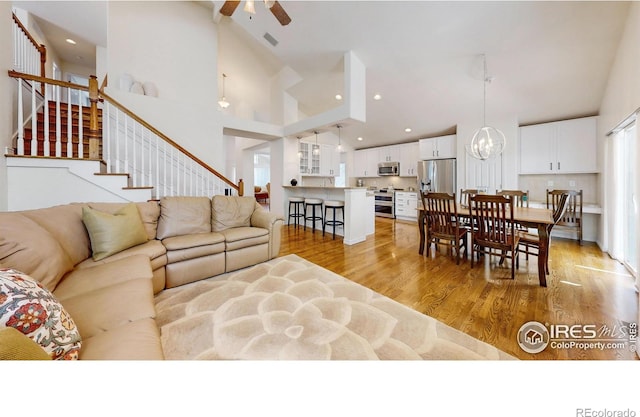 2139 Andrews St, Fort Collins, CO 80528 - living area featuring high vaulted ceiling, stairway, ceiling fan, light wood-style flooring, and recessed lighting