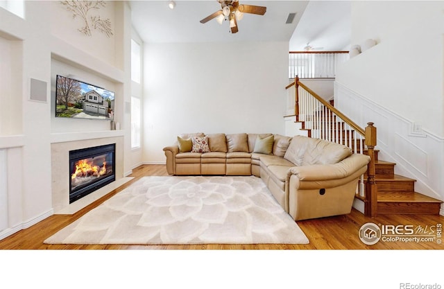 2139 Andrews St, Fort Collins, CO 80528 - living room with high vaulted ceiling, a ceiling fan, a fireplace, wood finished floors, and stairs