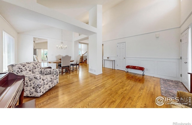 2139 Andrews St, Fort Collins, CO 80528 - living area featuring a chandelier, light wood-style flooring, wainscoting, and lofted ceiling