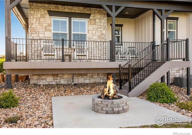 4268 Ardglass Ln, Timnath, CO 80547 - view of exterior entry featuring stone siding, board and batten siding, cooling unit, and a porch