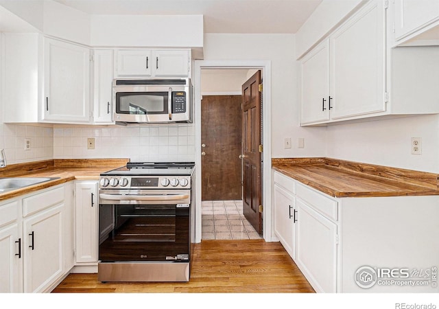 4116 W 111th Cir, Westminster, CO 80031 - kitchen with stainless steel appliances, white cabinetry, backsplash, light wood-style floors, and a sink