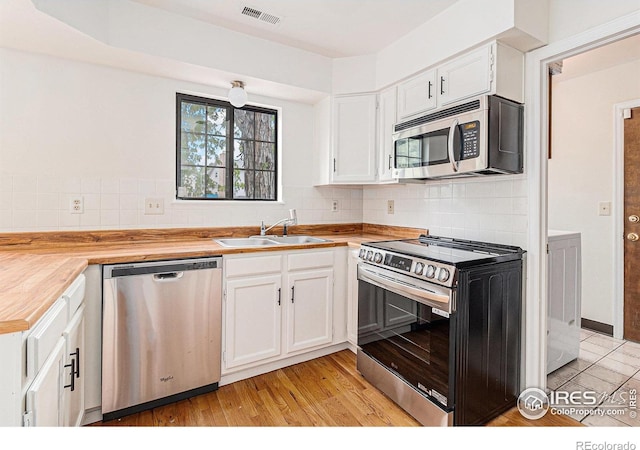 4116 W 111th Cir, Westminster, CO 80031 - kitchen featuring stainless steel appliances, a sink, white cabinets, and decorative backsplash