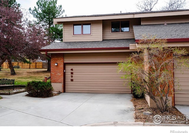 4570 Macarthur Dr, Boulder, CO 80303 - view of front of house featuring an attached garage, brick siding, driveway, and a shingled roof