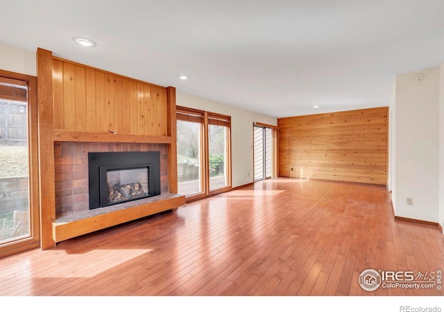 4570 Macarthur Dr, Boulder, CO 80303 - unfurnished living room featuring a glass covered fireplace, light wood finished floors, baseboards, recessed lighting, and wood walls