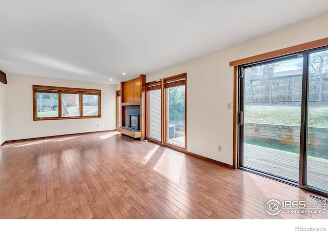 4570 Macarthur Dr, Boulder, CO 80303 - unfurnished living room with healthy amount of natural light, a fireplace with raised hearth, light wood-type flooring, and recessed lighting