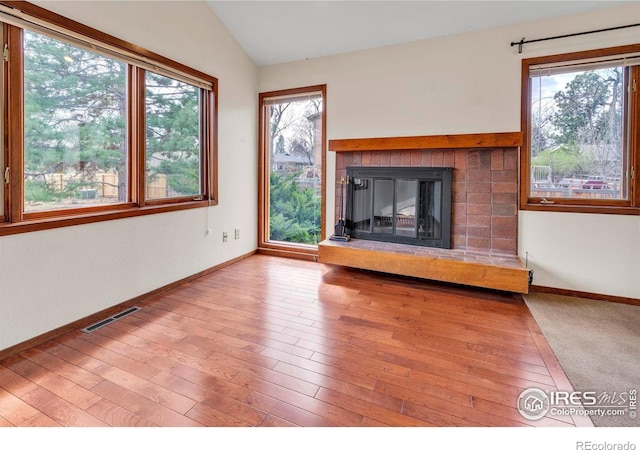 4570 Macarthur Dr, Boulder, CO 80303 - unfurnished living room featuring vaulted ceiling, a fireplace, wood finished floors, and baseboards