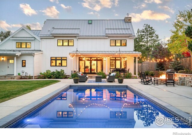 1505 Oak Ave, Boulder, CO 80304 - back of house featuring a standing seam roof, a patio, an outdoor living space with a fire pit, a chimney, and metal roof