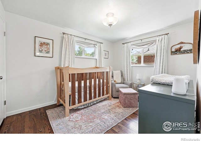 8290 Chase Way, Arvada, CO 80003 - bedroom featuring wood finished floors, a crib, and baseboards
