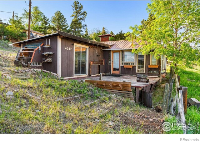 4402 Kano Dr, Fort Collins, CO 80526 - back of property featuring a wooden deck, a chimney, and metal roof