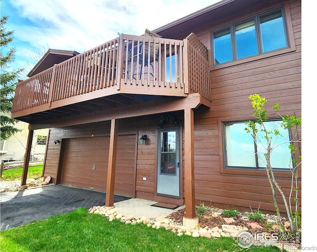 1443 Matthew Cir, Estes Park, CO 80517 - back of property with an attached garage, a balcony, and asphalt driveway