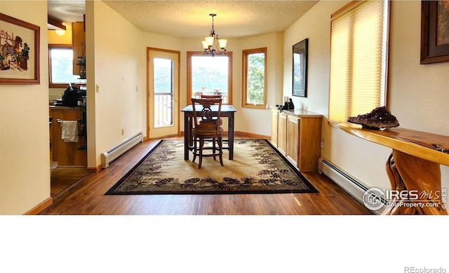 1443 Matthew Cir, Estes Park, CO 80517 - dining area featuring a baseboard radiator, a chandelier, dark wood finished floors, and a textured ceiling
