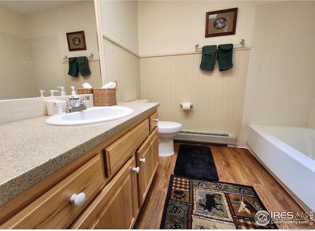 1443 Matthew Cir, Estes Park, CO 80517 - full bathroom featuring baseboard heating, wood finished floors, vanity, toilet, and a wainscoted wall
