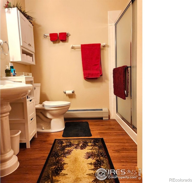 1443 Matthew Cir, Estes Park, CO 80517 - bathroom with baseboard heating, a stall shower, wood finished floors, and toilet