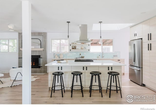 4601 S Lipan St, Englewood, CO 80110 - kitchen featuring freestanding refrigerator, island range hood, a kitchen bar, and a spacious island