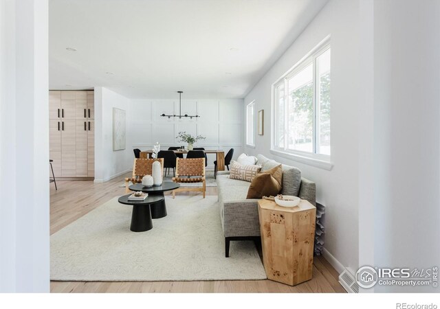 4601 S Lipan St, Englewood, CO 80110 - living room featuring wood finished floors, a chandelier, and baseboards