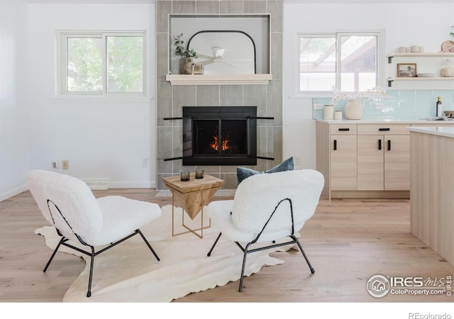 4601 S Lipan St, Englewood, CO 80110 - living area with light wood finished floors, a tile fireplace, and baseboards