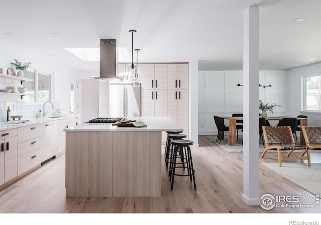 4601 S Lipan St, Englewood, CO 80110 - kitchen featuring refrigerator, island range hood, a sink, and modern cabinets