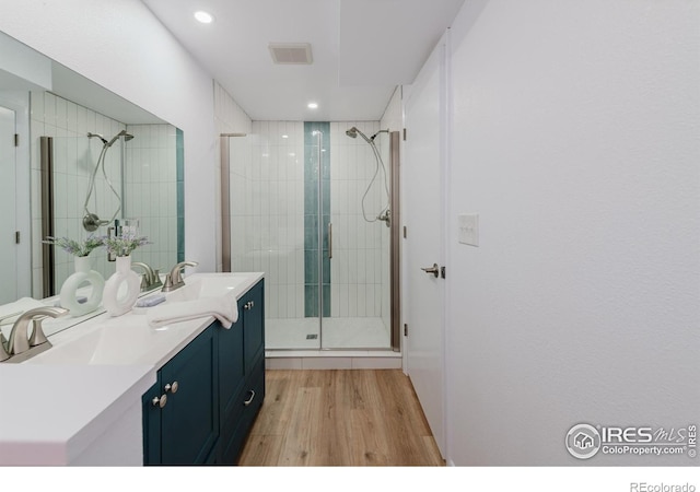 4601 S Lipan St, Englewood, CO 80110 - bathroom featuring wood finished floors, a stall shower, double vanity, and recessed lighting