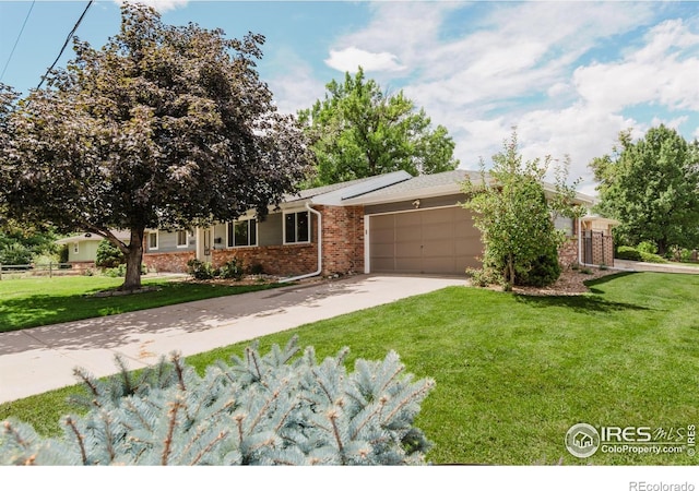 4601 S Lipan St, Englewood, CO 80110 - view of front of house with brick siding, an attached garage, driveway, and a front lawn