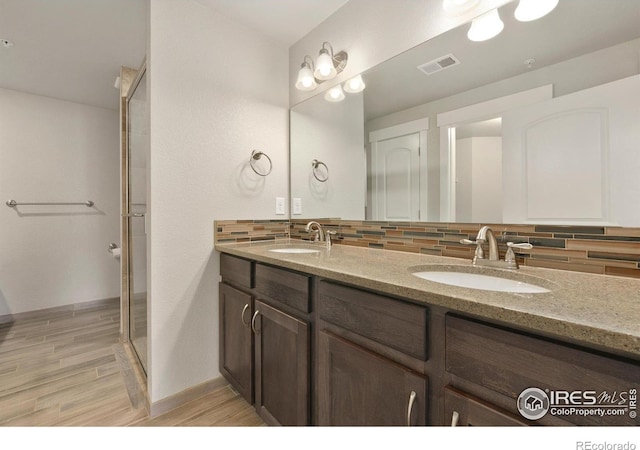 4902 Brookfield Dr Unit F, Fort Collins, CO 80528 - bathroom featuring tasteful backsplash, double vanity, wood finished floors, a shower stall, and baseboards
