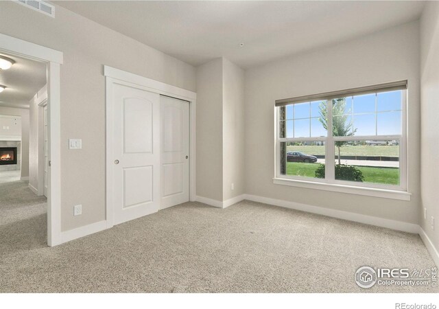 4902 Brookfield Dr Unit F, Fort Collins, CO 80528 - unfurnished bedroom with carpet flooring, baseboards, a closet, and a fireplace