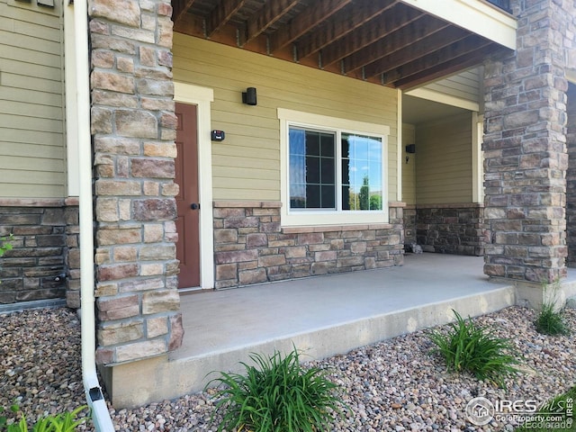 4902 Brookfield Dr Unit F, Fort Collins, CO 80528 - view of exterior entry featuring stone siding and a porch