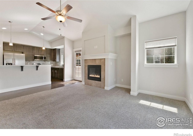 4902 Brookfield Dr Unit F, Fort Collins, CO 80528 - unfurnished living room featuring carpet flooring, lofted ceiling, ceiling fan, a tiled fireplace, and baseboards