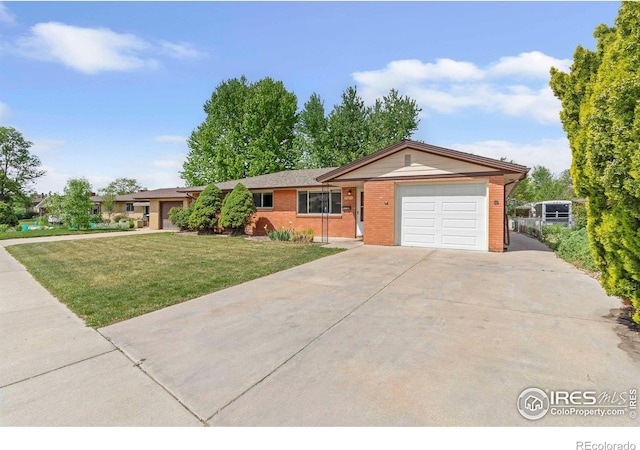 1229 Juniper St, Longmont, CO 80501 - ranch-style home featuring an attached garage, concrete driveway, brick siding, and a front lawn