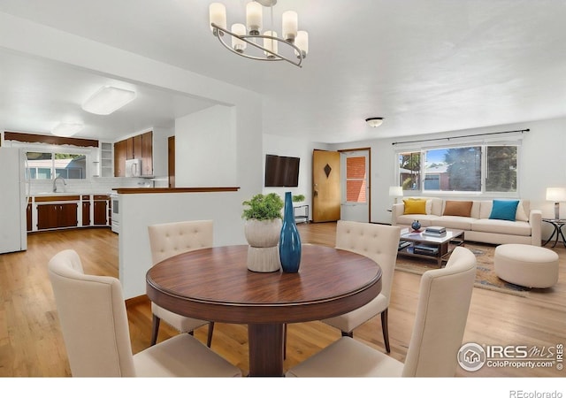 1229 Juniper St, Longmont, CO 80501 - dining space with a chandelier and light wood-style floors