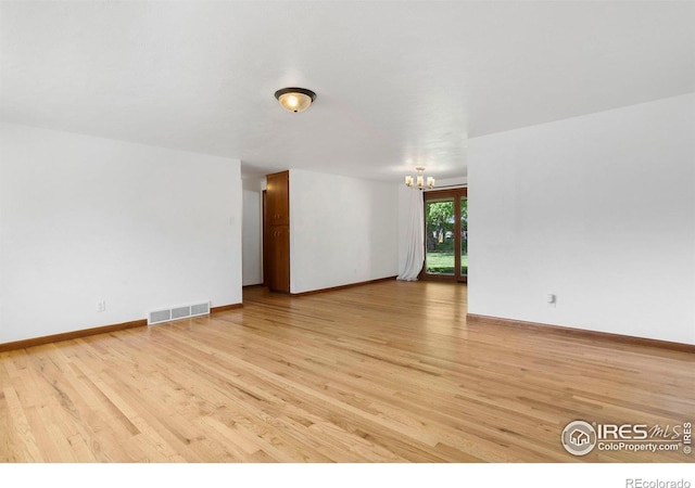 1229 Juniper St, Longmont, CO 80501 - unfurnished room with a chandelier, light wood finished floors, and baseboards
