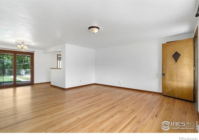 1229 Juniper St, Longmont, CO 80501 - unfurnished living room featuring a chandelier, light wood finished floors, and baseboards