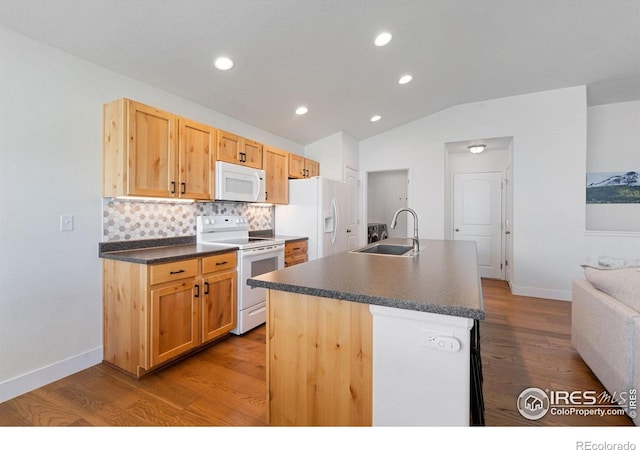 1566 Driftline Dr, Severance, CO 80550 - kitchen with white appliances, a sink, dark countertops, vaulted ceiling, and wood finished floors