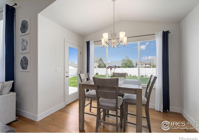 1566 Driftline Dr, Severance, CO 80550 - dining space featuring light wood-style floors, vaulted ceiling, a chandelier, and baseboards