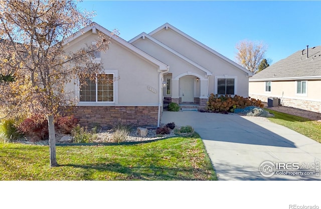 8211 Lighthouse Lane Ct, Windsor, CO 80528 - view of front of home with stone siding, central AC, stucco siding, driveway, and a front lawn
