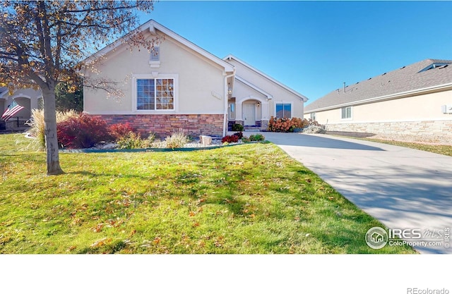 8211 Lighthouse Lane Ct, Windsor, CO 80528 - view of front of house featuring stucco siding, stone siding, a front yard, and driveway